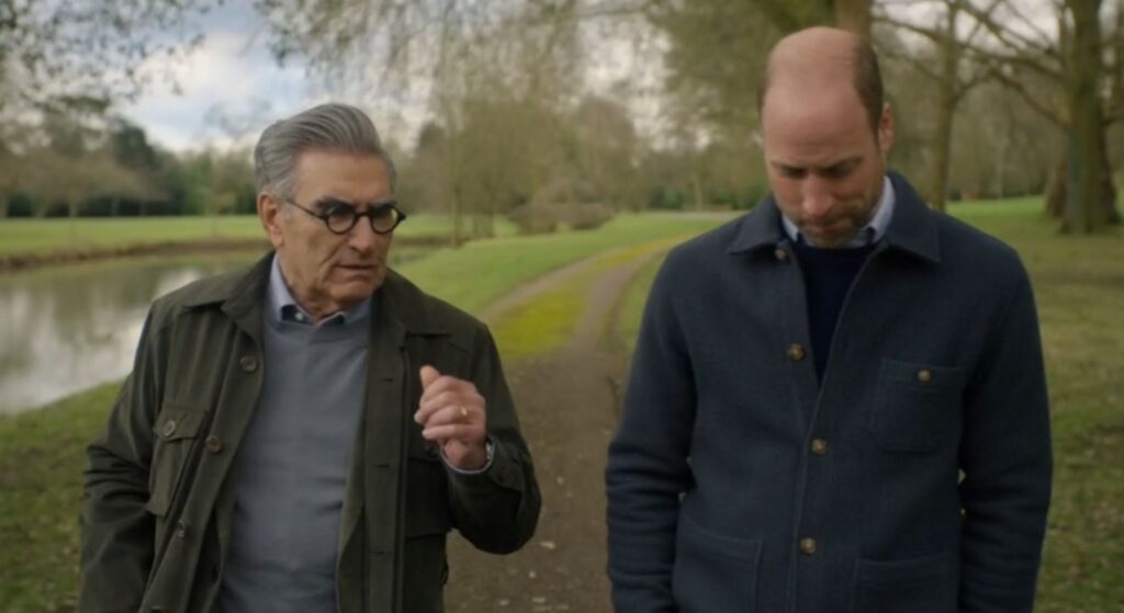 Eugene Levy talking to Prince William in The Reluctant Traveler