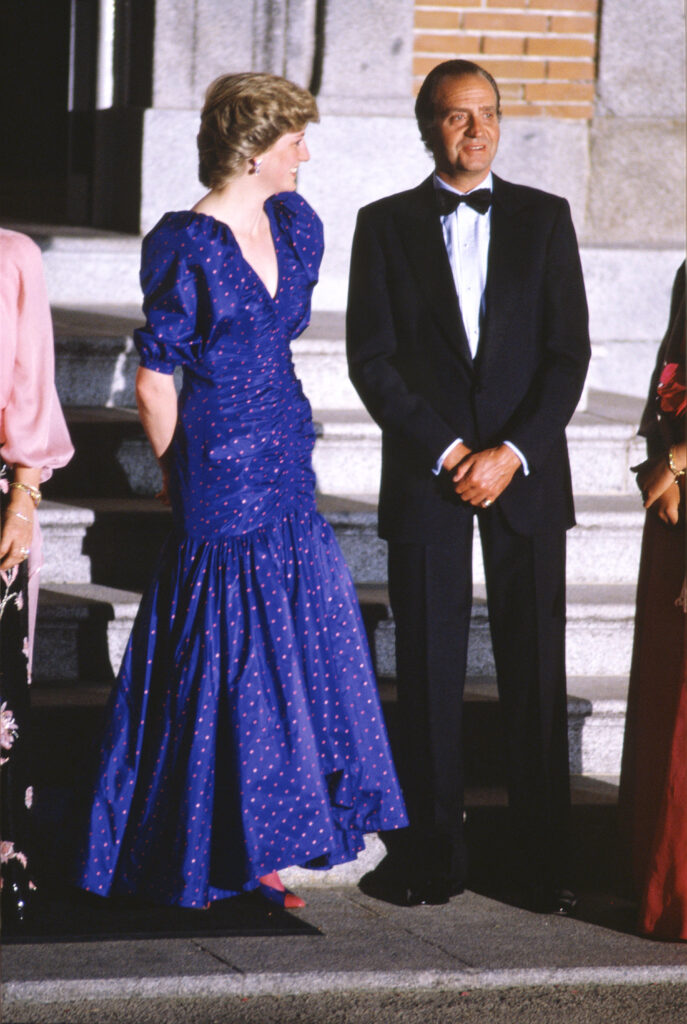 Princess Diana laughing and smiling as she looks at King Juan Carlos whilst she wears a long blue dress