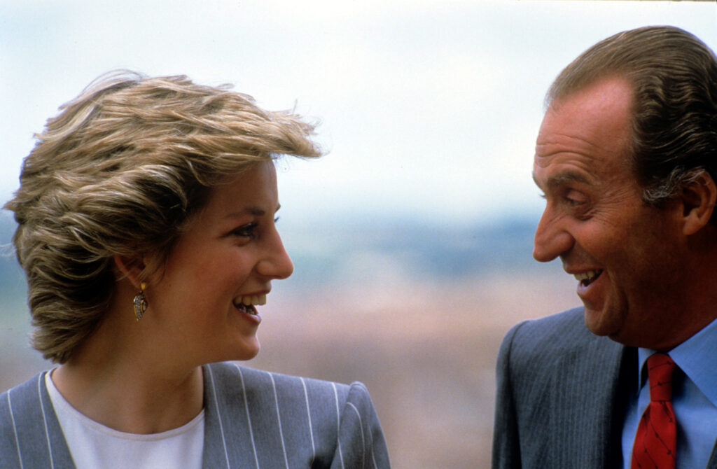 Princess Diana laughing and smiling as she looks at King Juan Carlos who is also grinning