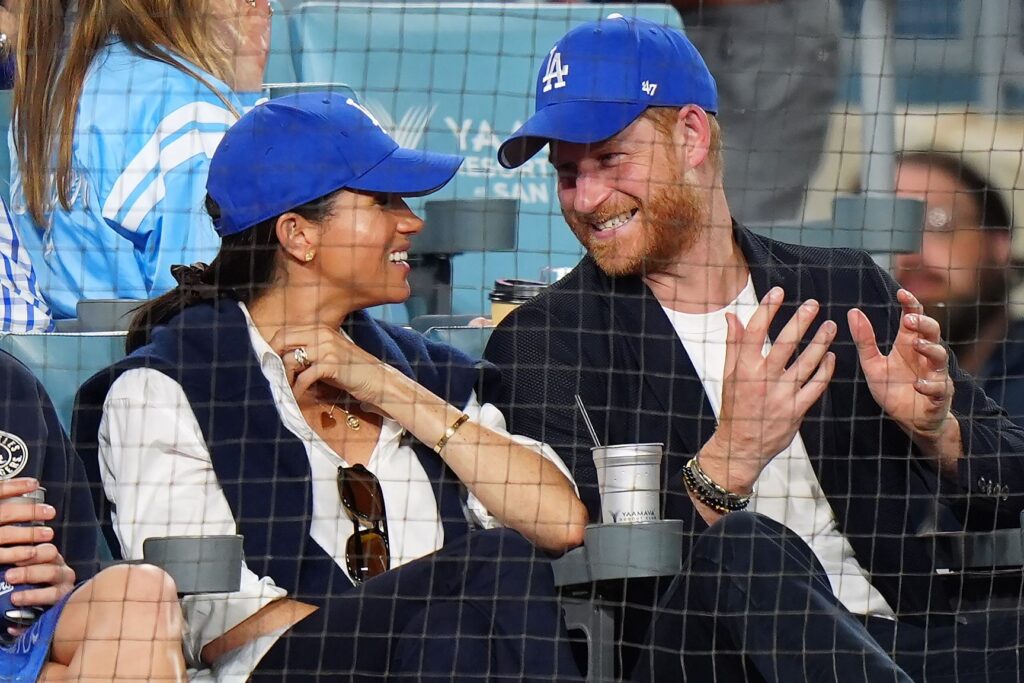 Meghan Markle and Prince Harry smiling at each other at Dodgers game