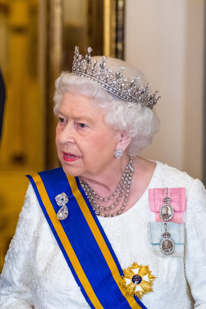 Queen Elizabeth II frowning whilst wearing a crown