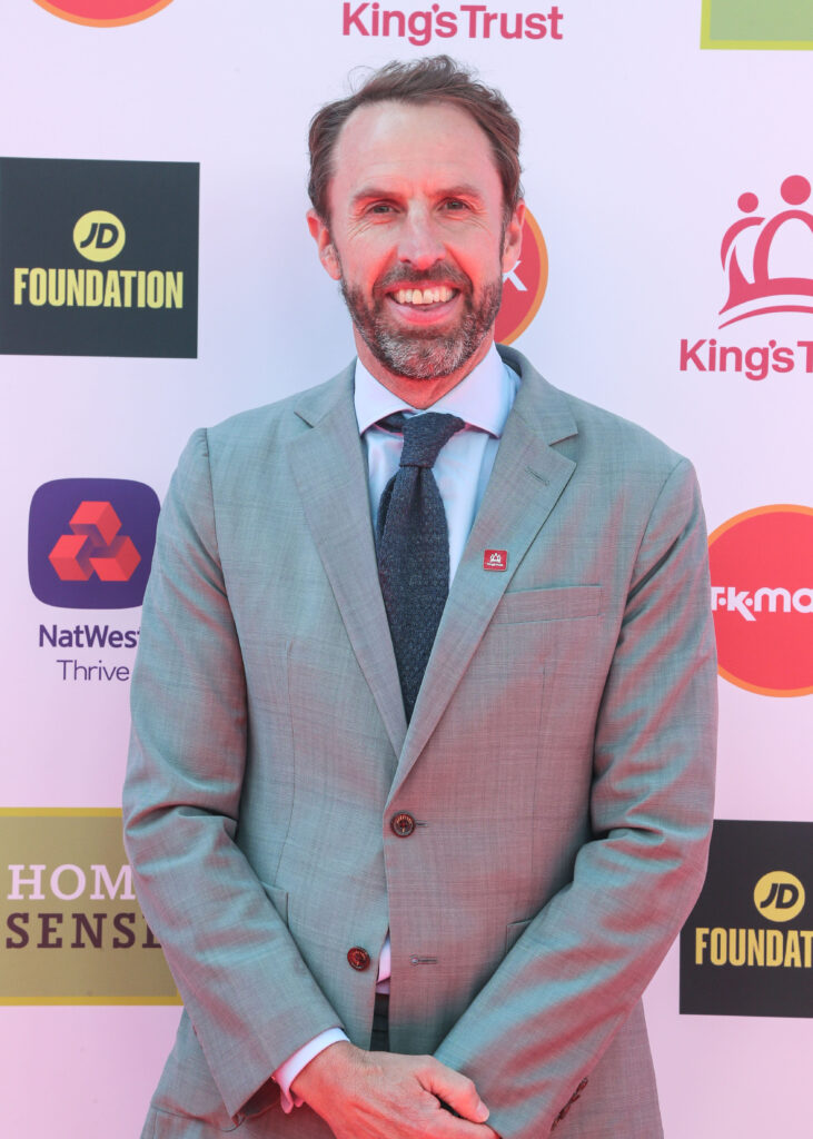 Sir Gareth Southgate smiling wearing a grey suit