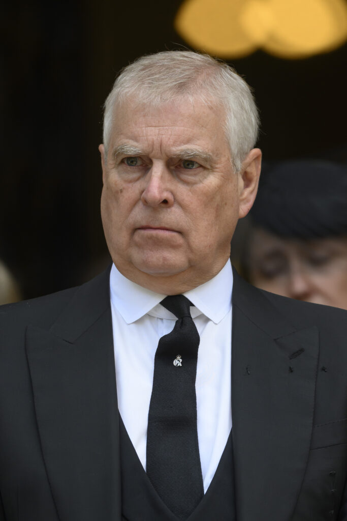 Prince Andrew in a black suit and tie looking serious