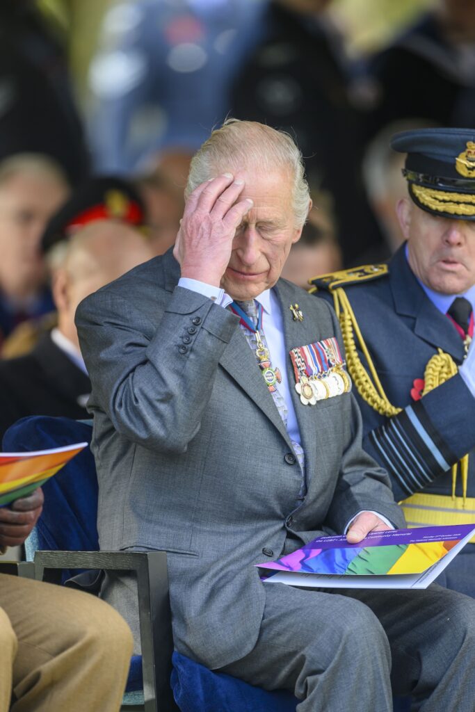 King Charles holding his head while at a public event