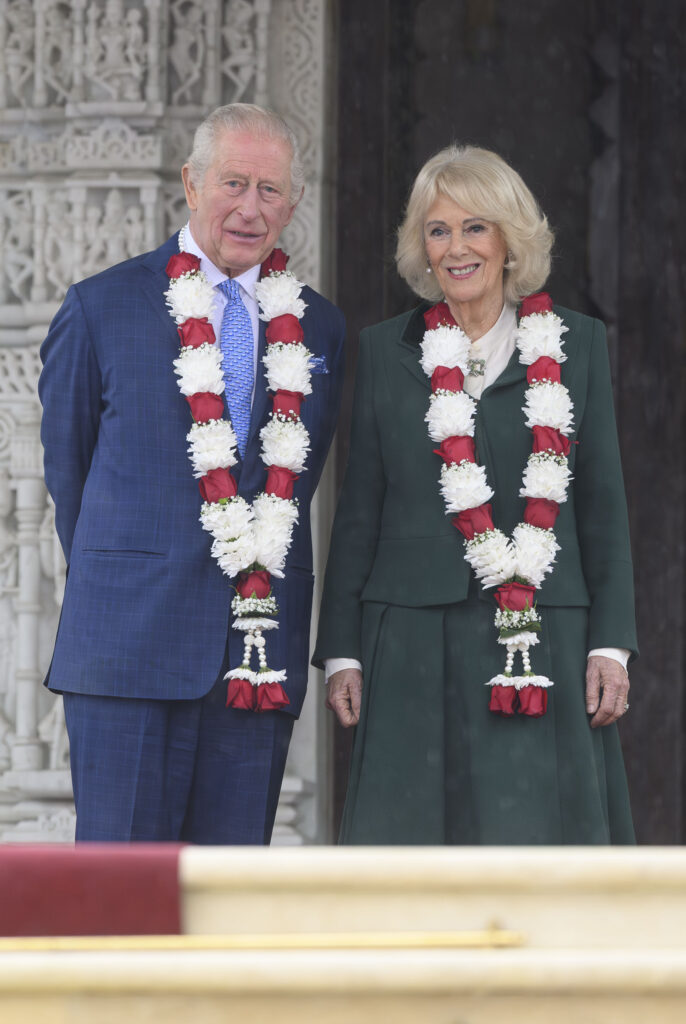 King Charles and Queen Camilla standing together and smiling 