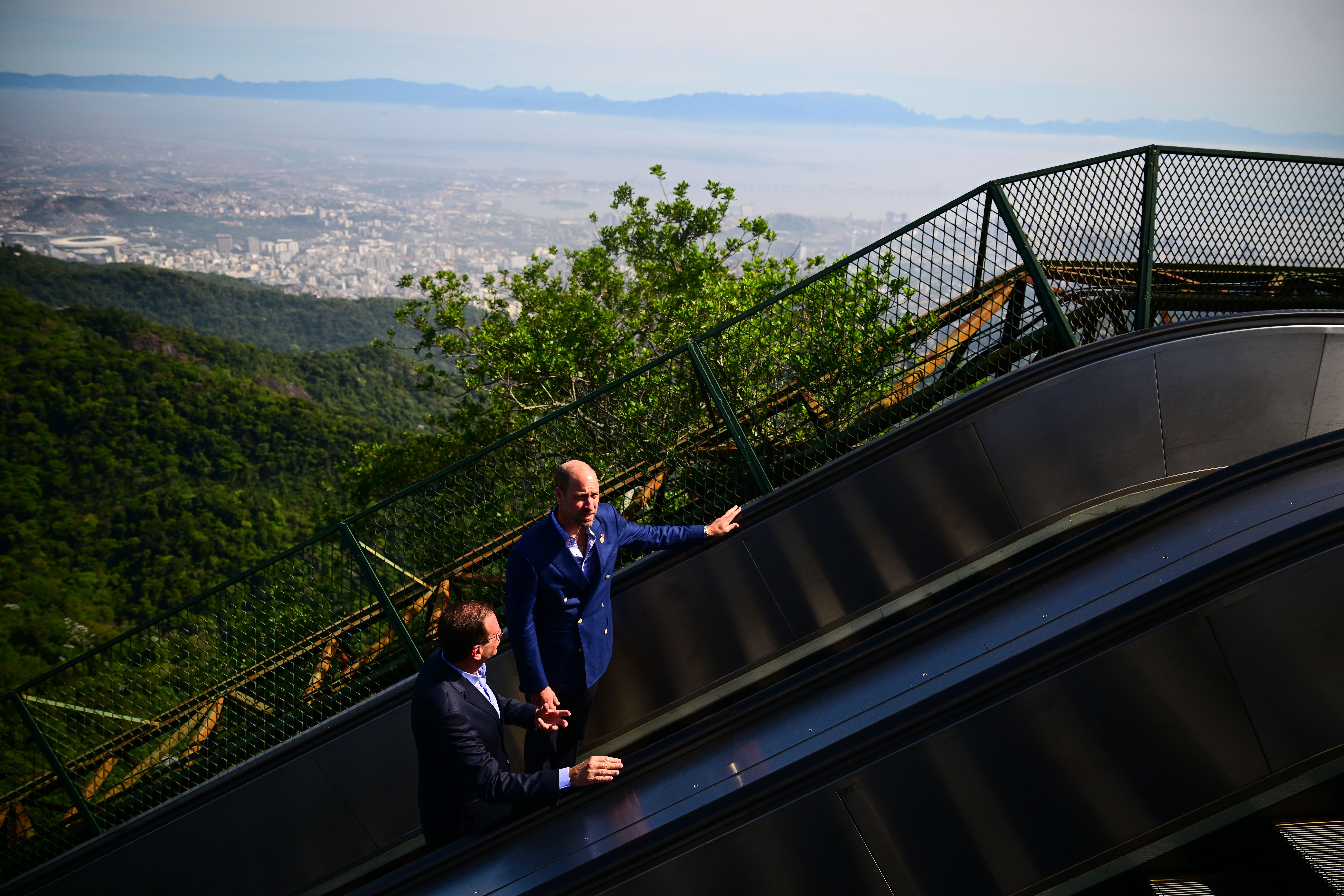 Prince William and Eduardo Paes, Mayor of Rio de Janeiro travel on the escalator leading up to Christ The Redeemer, the same place Princess Diana visited in April 1991