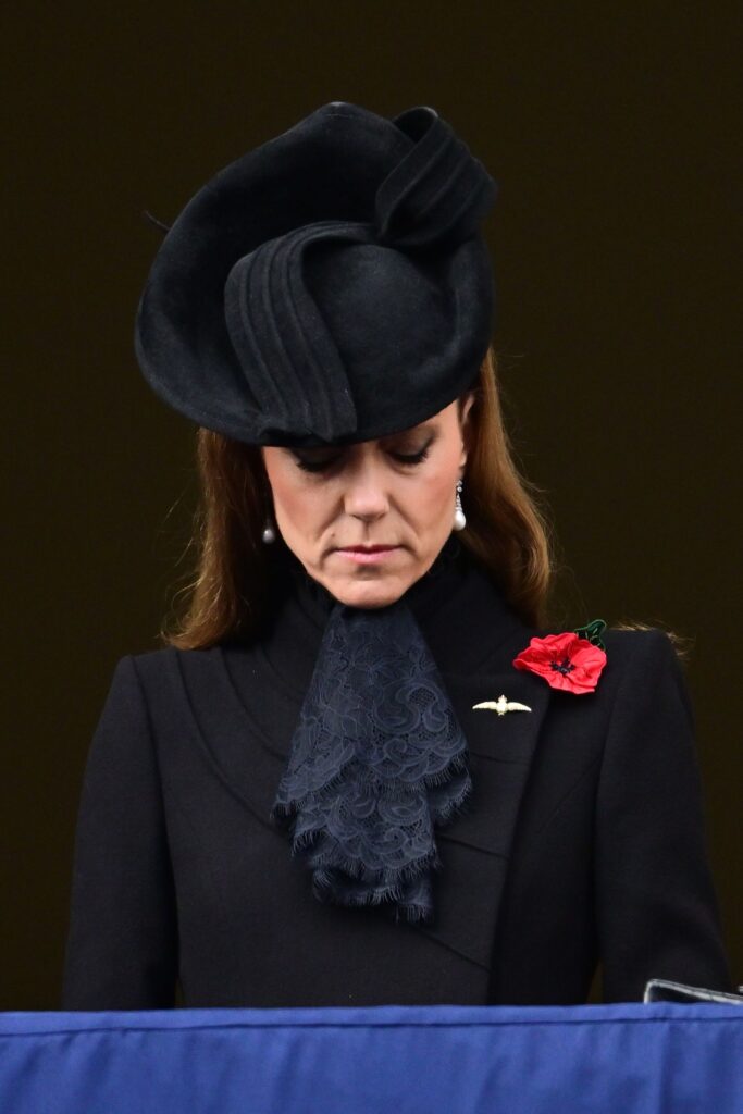 Princess Kate Middleton wearing a black hat, coat and lace ruffled scarf