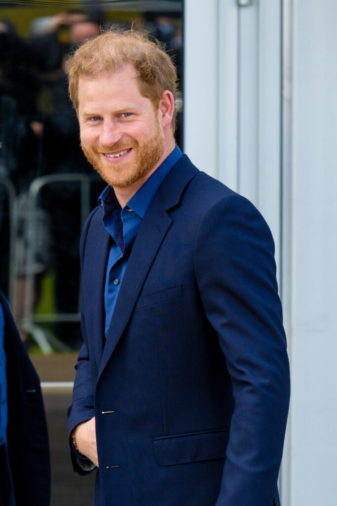 Prince Harry smiling wearing a blue suit 
