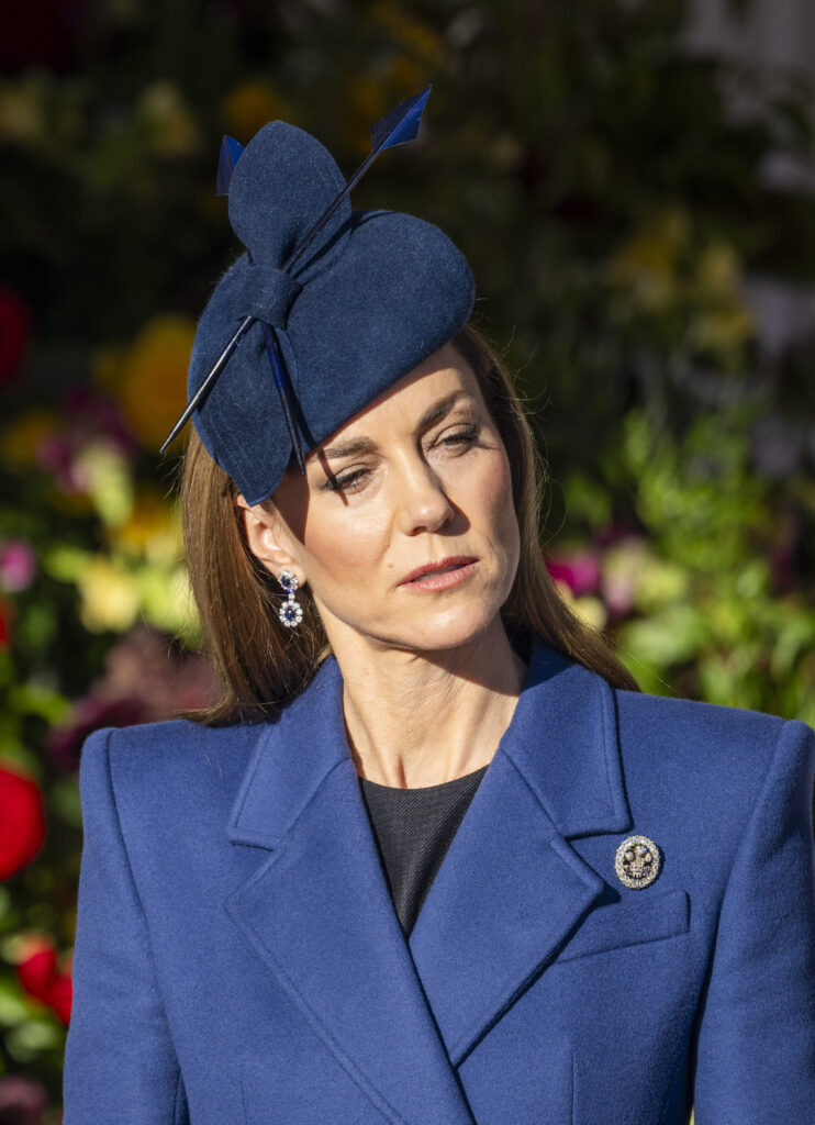 Princess Kate frowning wearing a blue ensemble