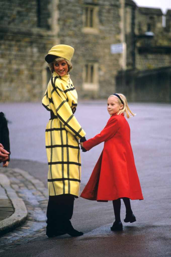 Princess Diana and Lady Rose Windsor on Christmas Day 1987, Diana wearing a long yellow coat and hat with black stripes