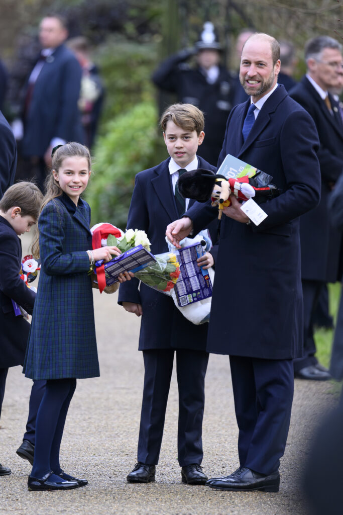 Prince Louis, Princess Charlotte, Prince George and Prince William holding presents on Christmas Day