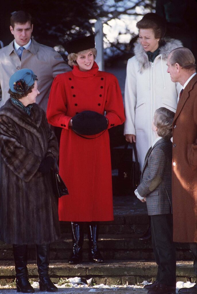 Princess Diana wearing a black hat and a long red coat, Sandringham 1985 on Christmas Day.