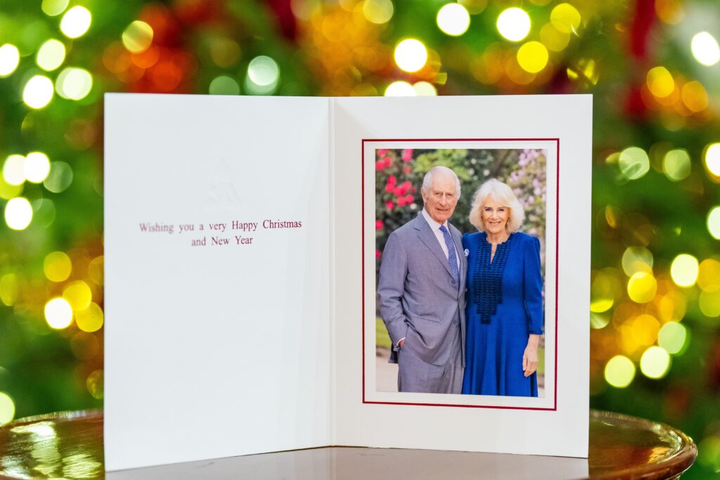 King Charles and Queen Camilla in front of a Christmas tree at Buckingham Palace