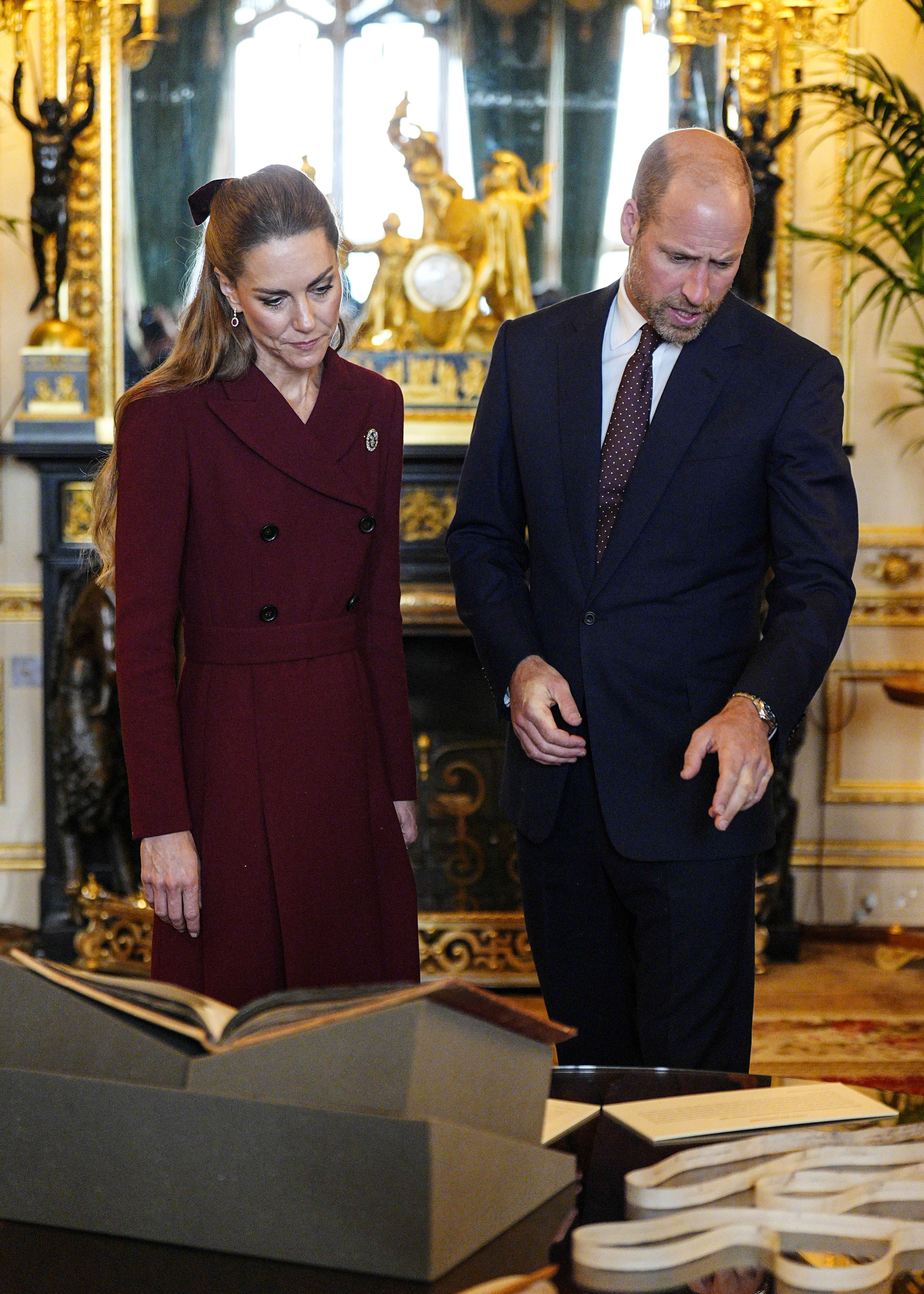 Princess Kate and Prince William looking down at papers together