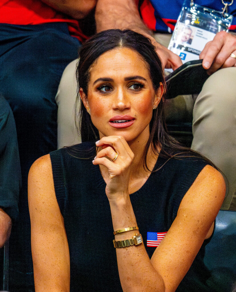 Meghan Markle frowning, holding her chin