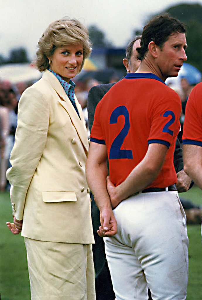 Princess Diana smiling whilst Prince Charles looks away from the camera