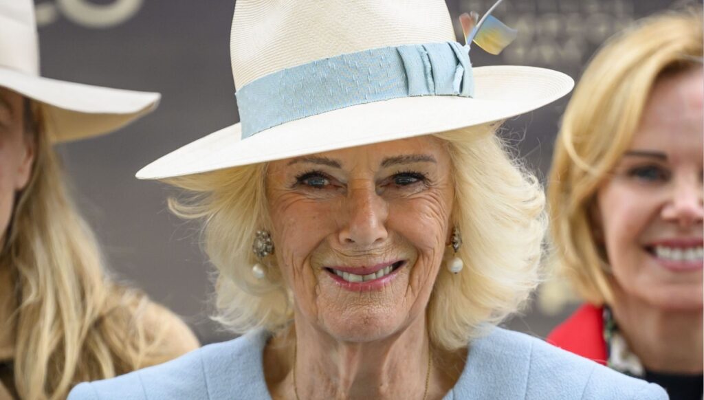 Queen Camilla smiling in blue outfit