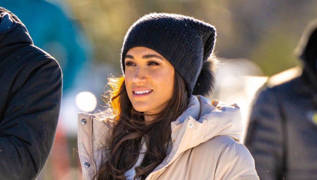 Meghan Markle in a white coat and black beanie