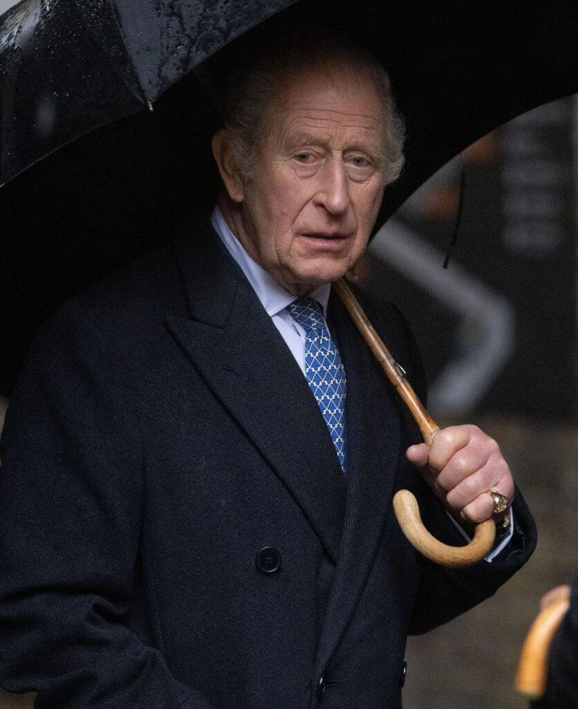 King Charles holding an umbrella