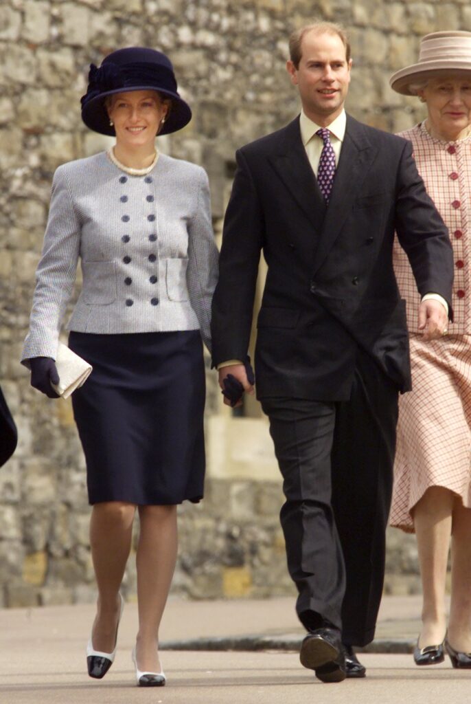 Duchess Sophie smiling beside Prince Edward as they walk hand in hand