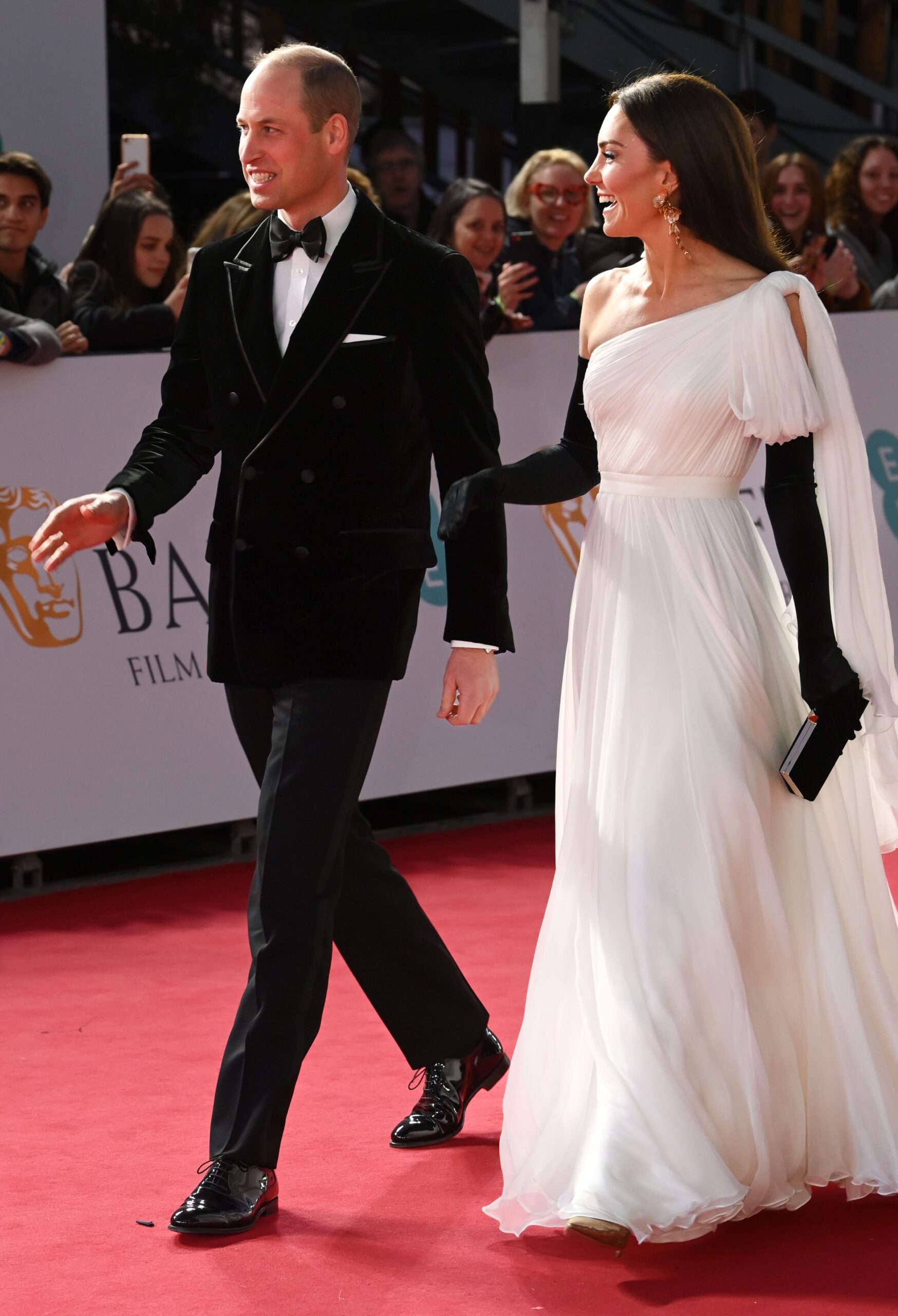 Prince William wearing a tuxedo beside Princess Kate wearing a long white dress at the BAFTAs in 2023