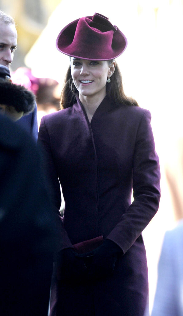 Princess Kate wearing a burgundy coat dress and velvet hat at Sandringham on Christmas day 2011