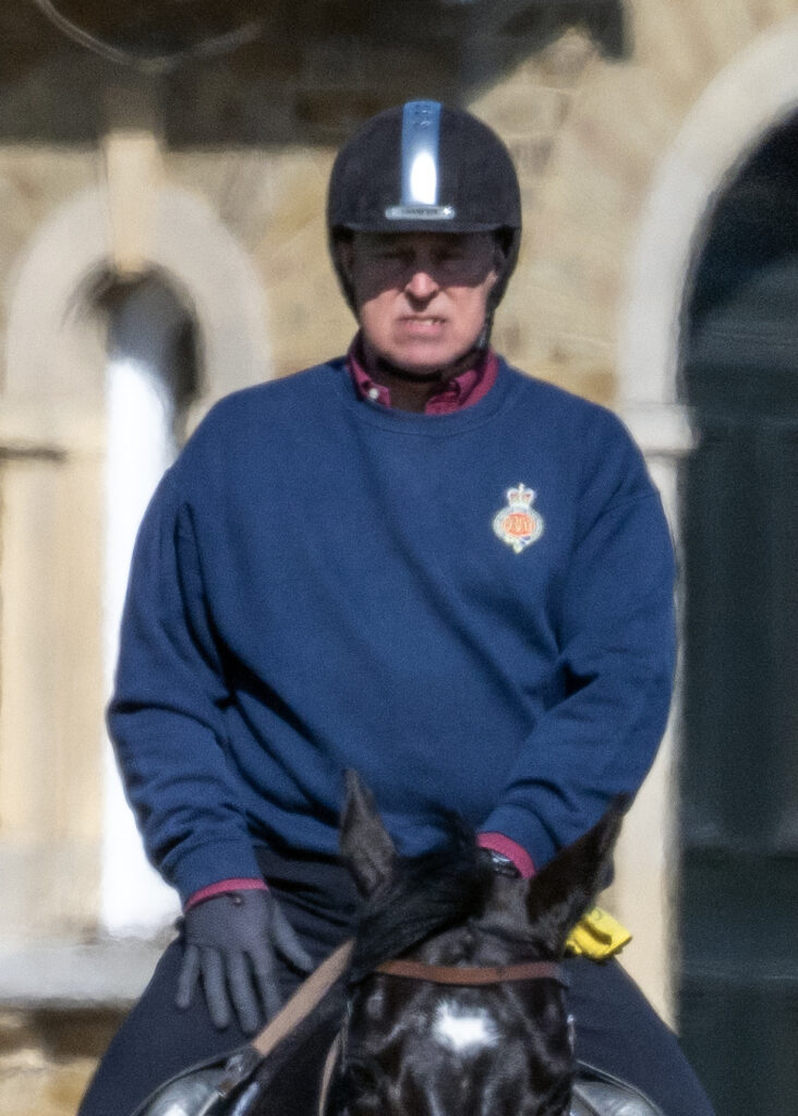 Andrew Mountbatten-Windsor scowling as he sits on top of a horse wearing a riding hat