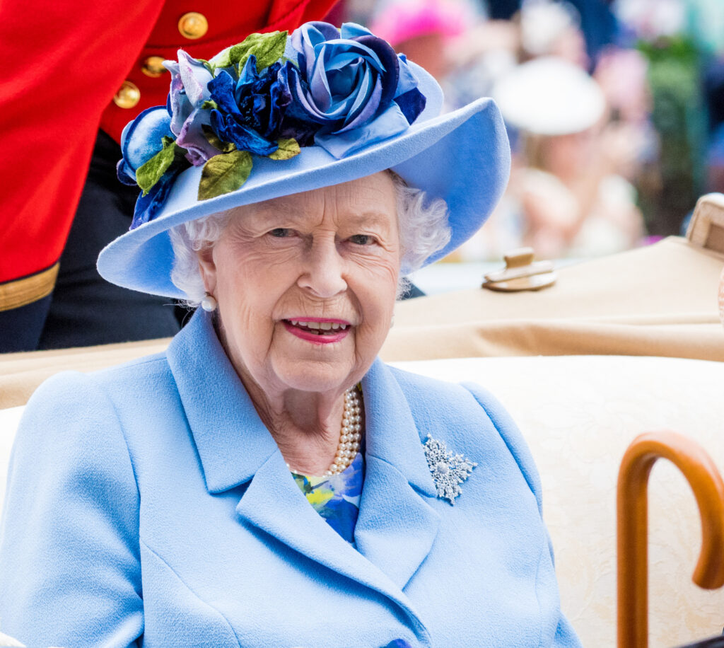 Queen Elizabeth II smiling wearing blue