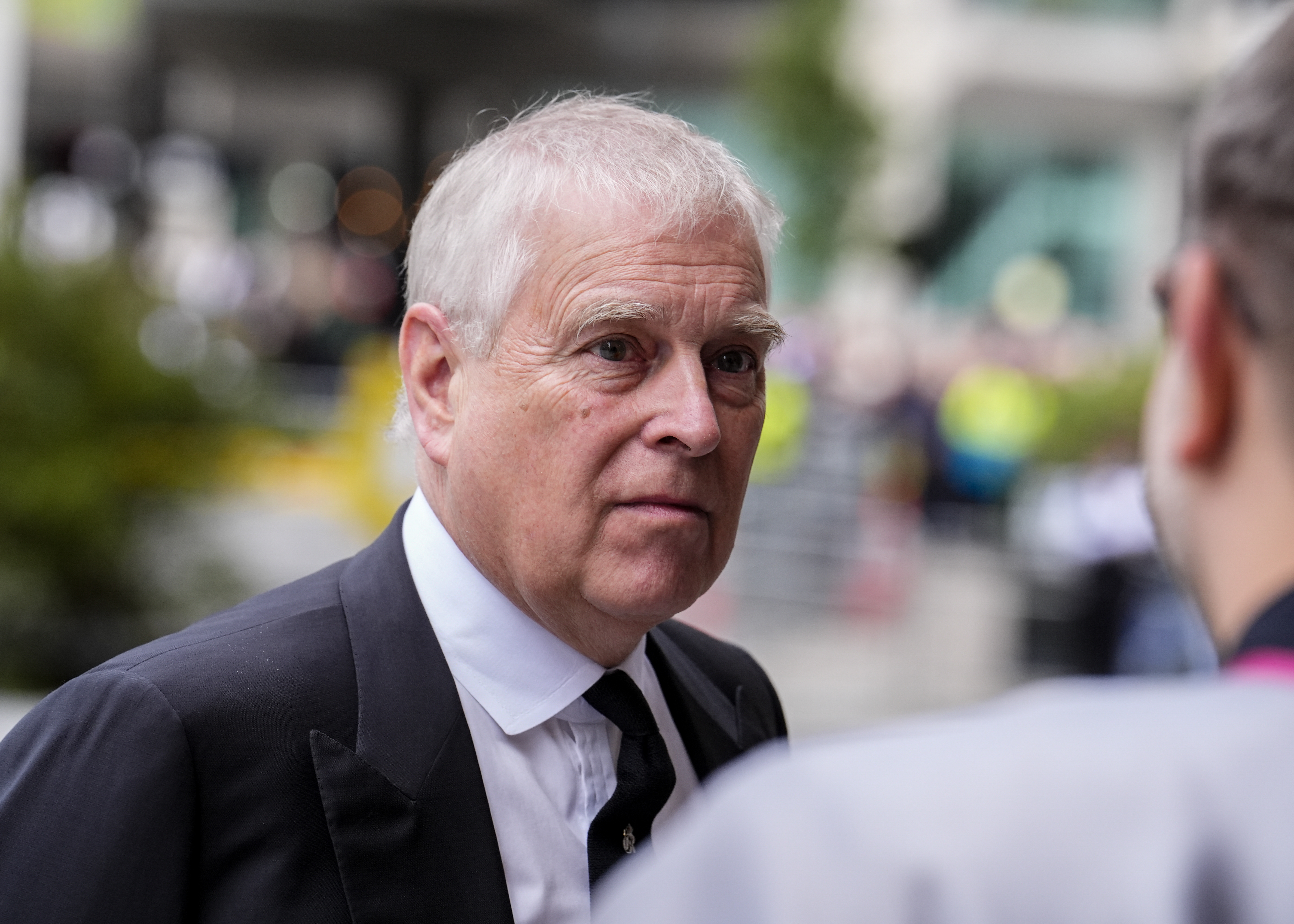 Andrew Mountbatten-Windsor frowning wearing a black suit