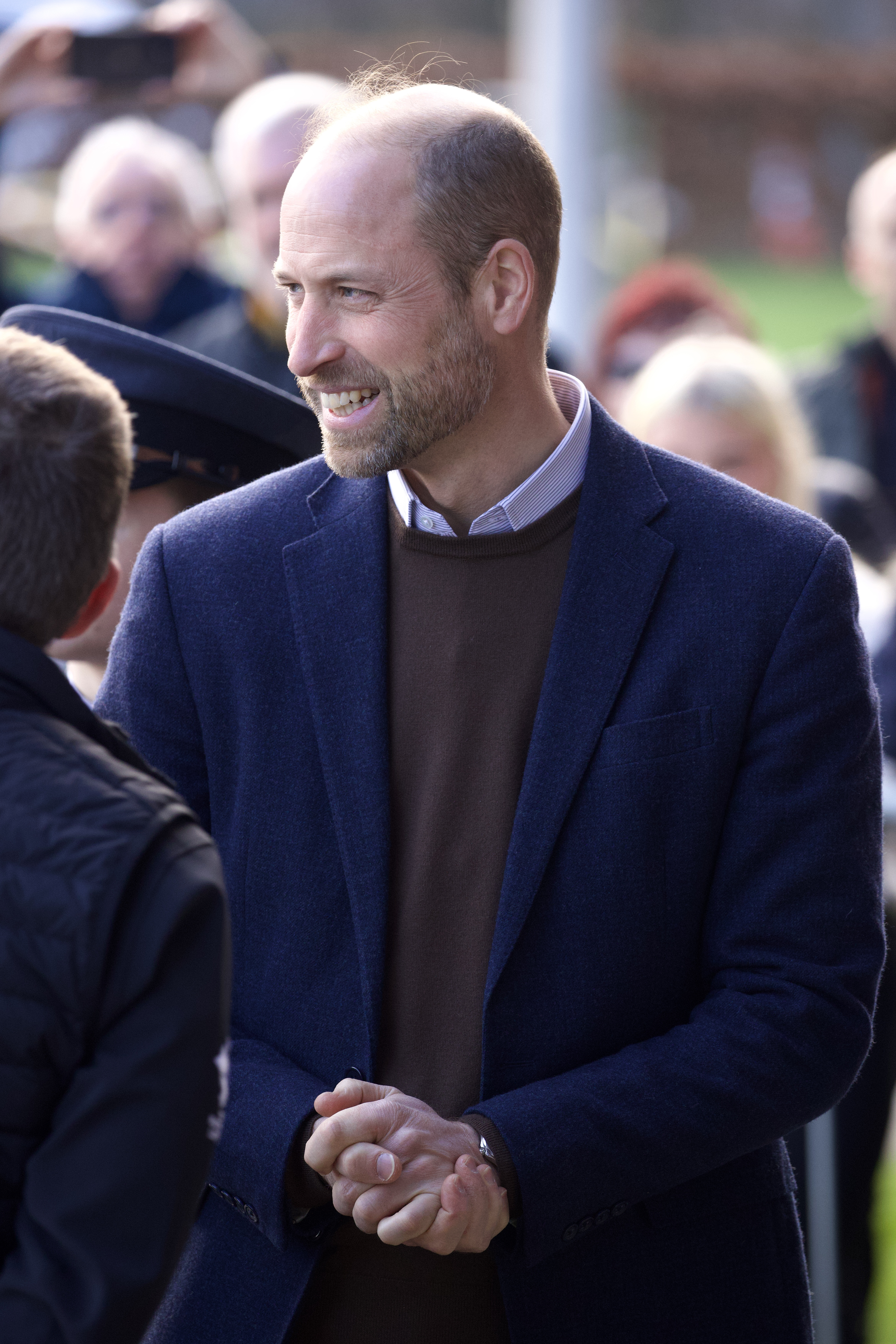 Prince William smiling and clasping his hands