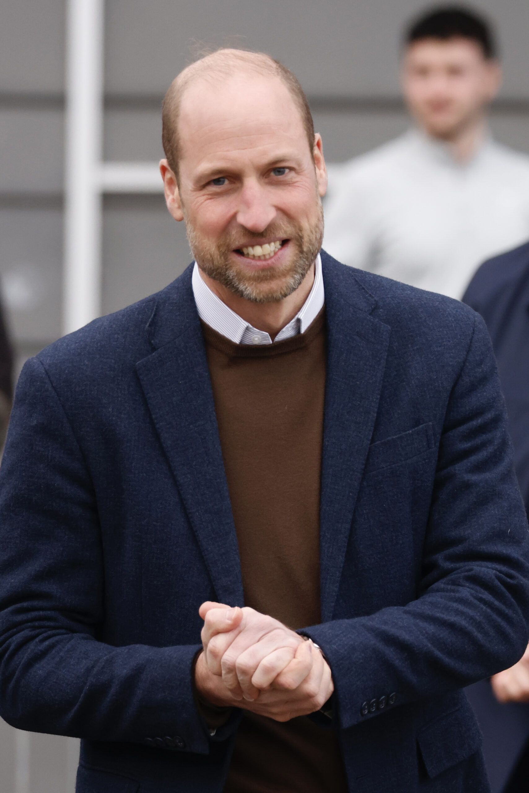 Prince William smiling, clasping his hands