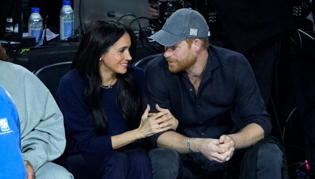 Meghan Markle and Prince Harry looking at each other at NBA game