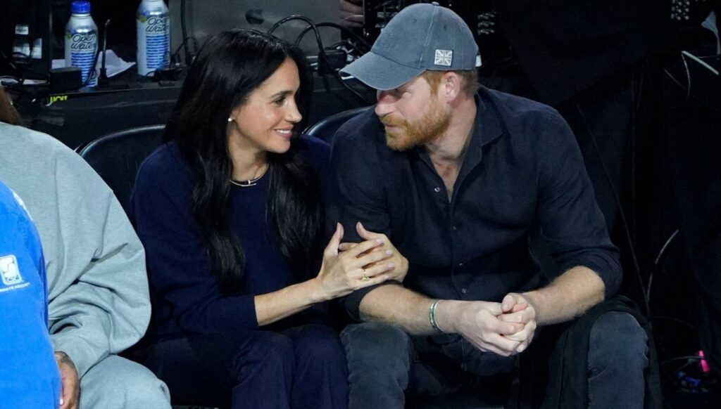 Meghan Markle and Prince Harry looking at each other at NBA game