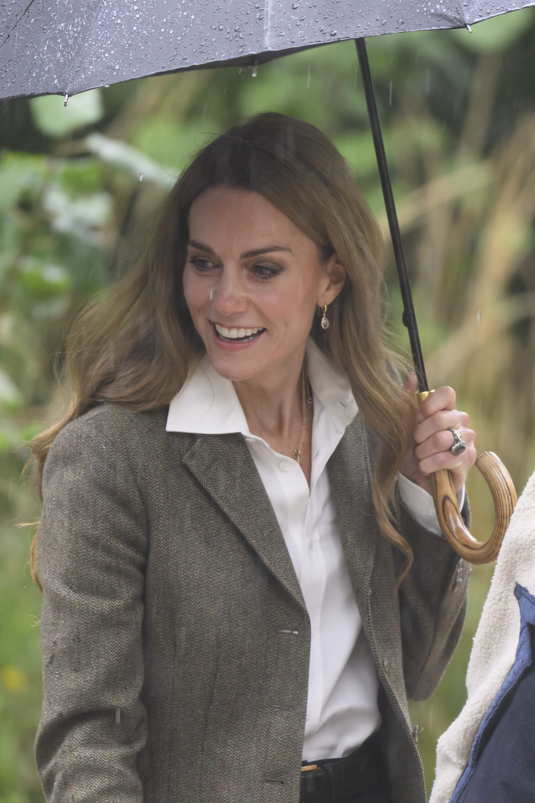 Kate Middleton holding an umbrella, smiling