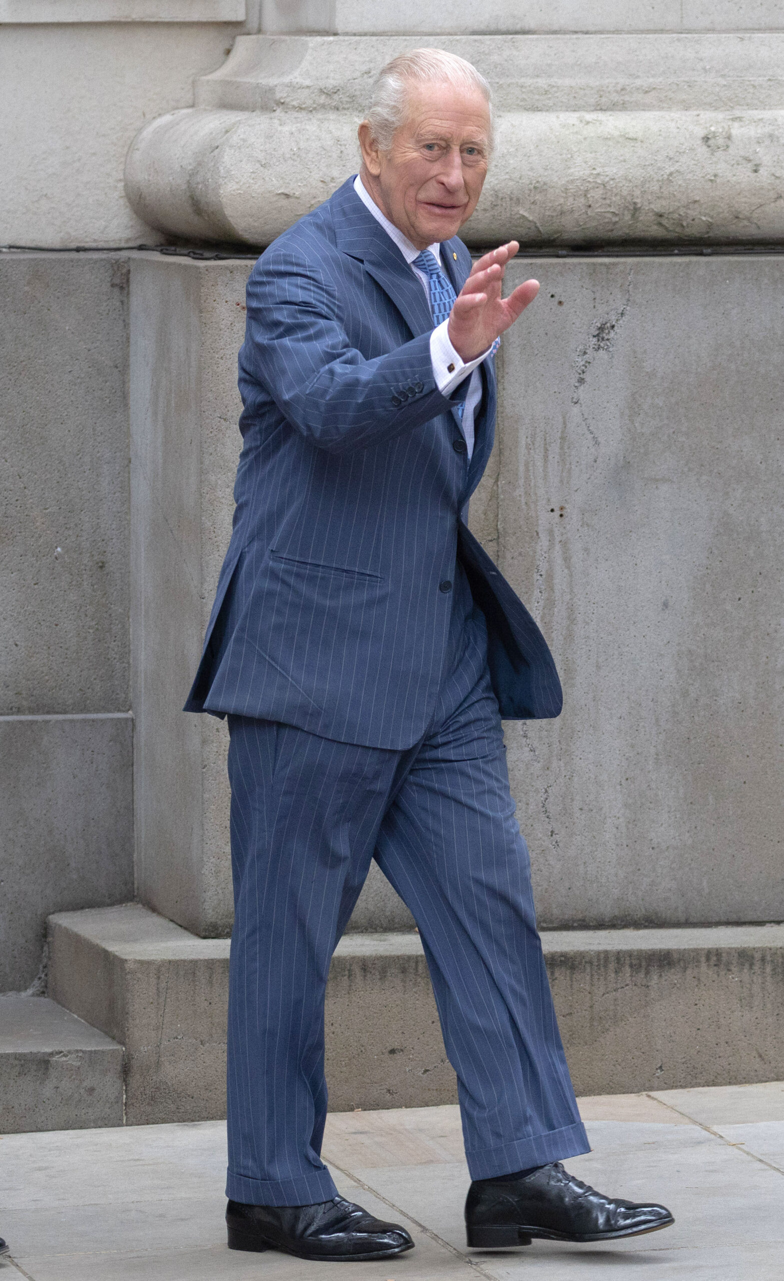 King Charles in blue suit, waving, on royal engagement