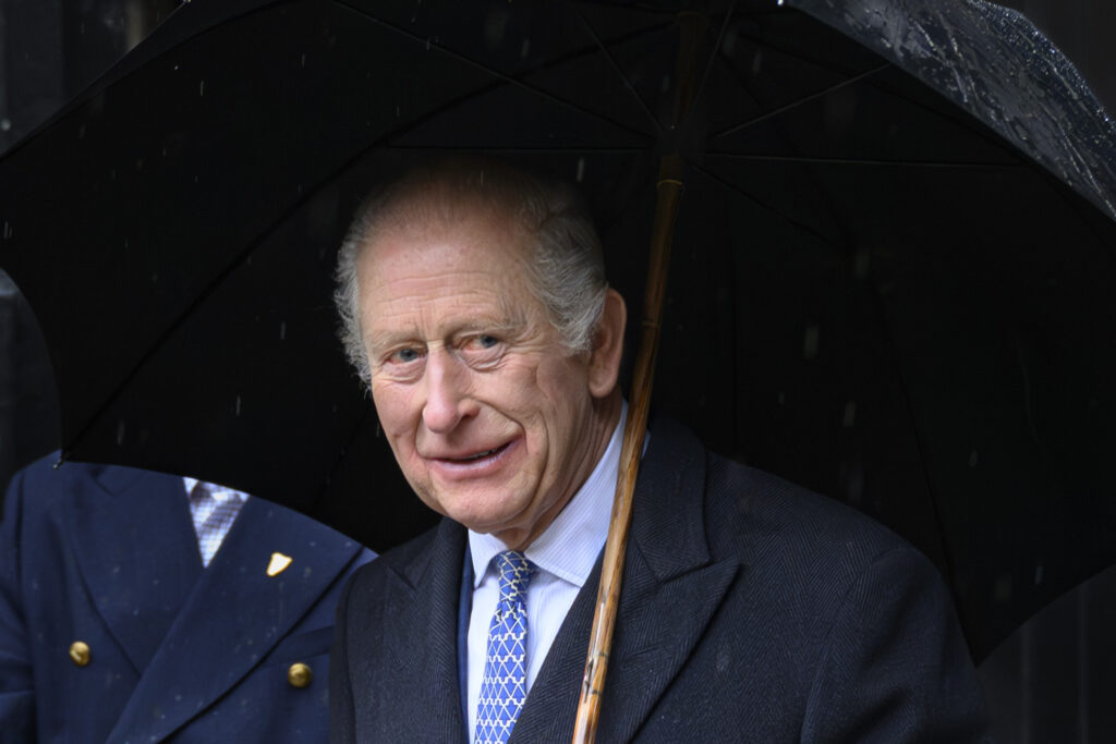 King Charles holding an umbrella 