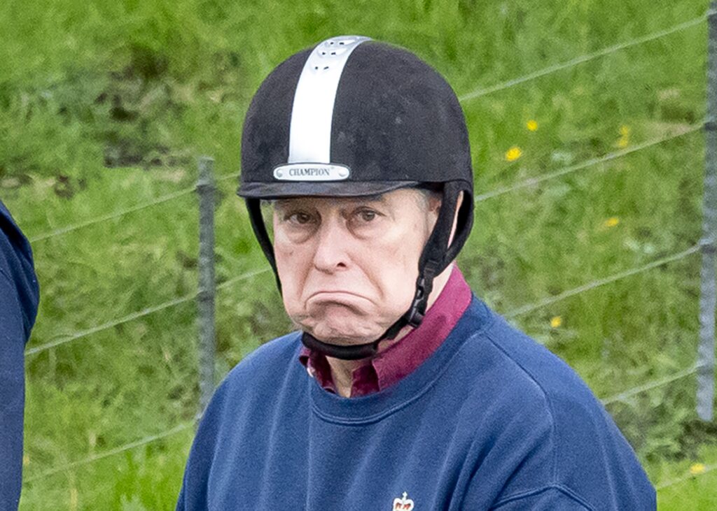 Andrew Mountbatten-Windsor frowning wearing a riding hat