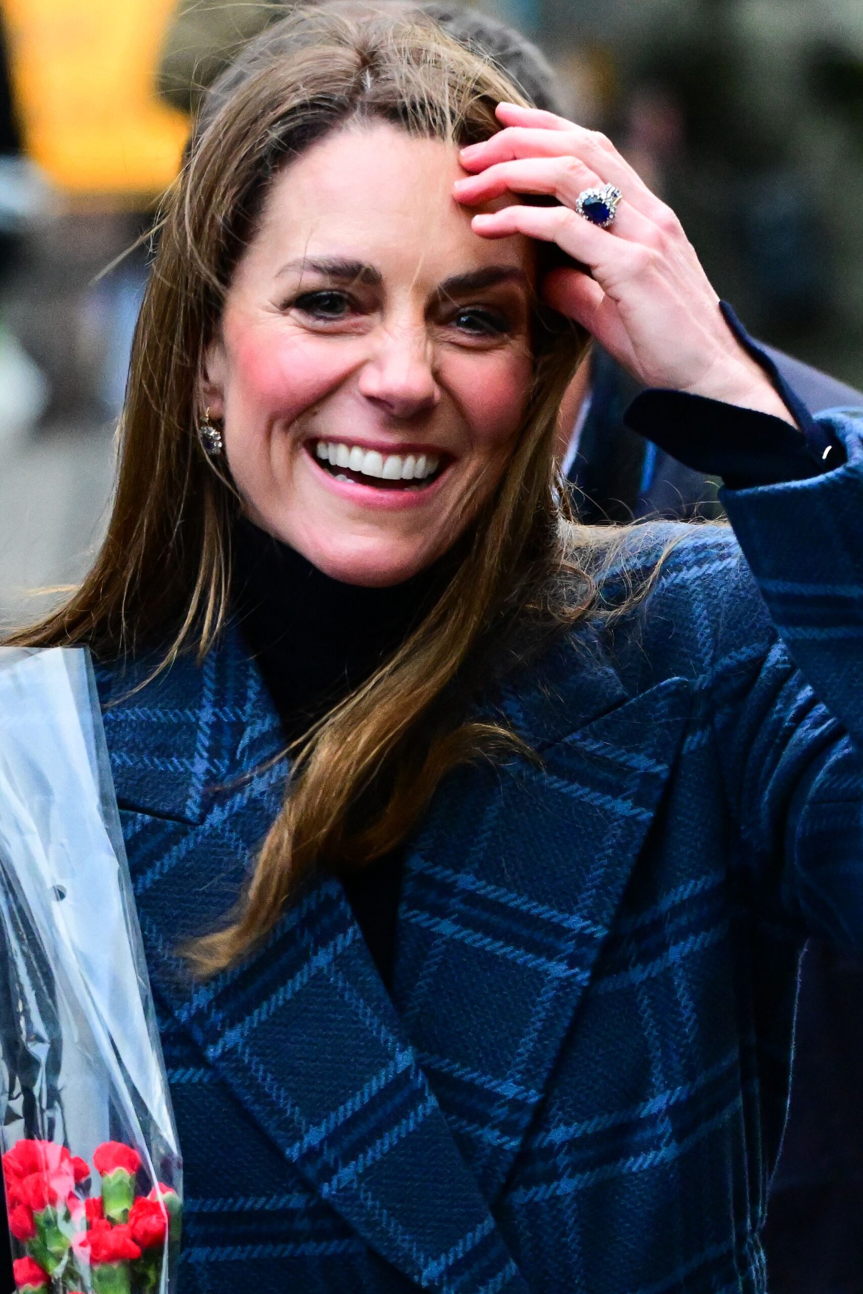 Princess Kate laughing and pushing her hair back