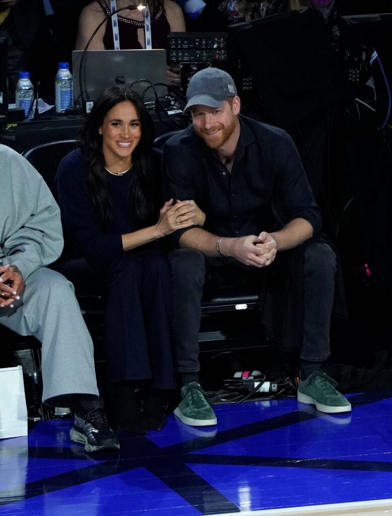 Meghan Markle and Prince Harry smiling and cuddling at NBA game
