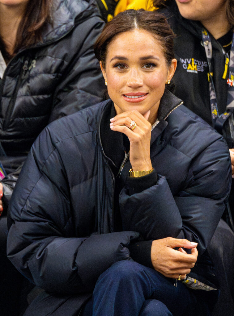 Meghan Markle smiling with her chin rested in her hand