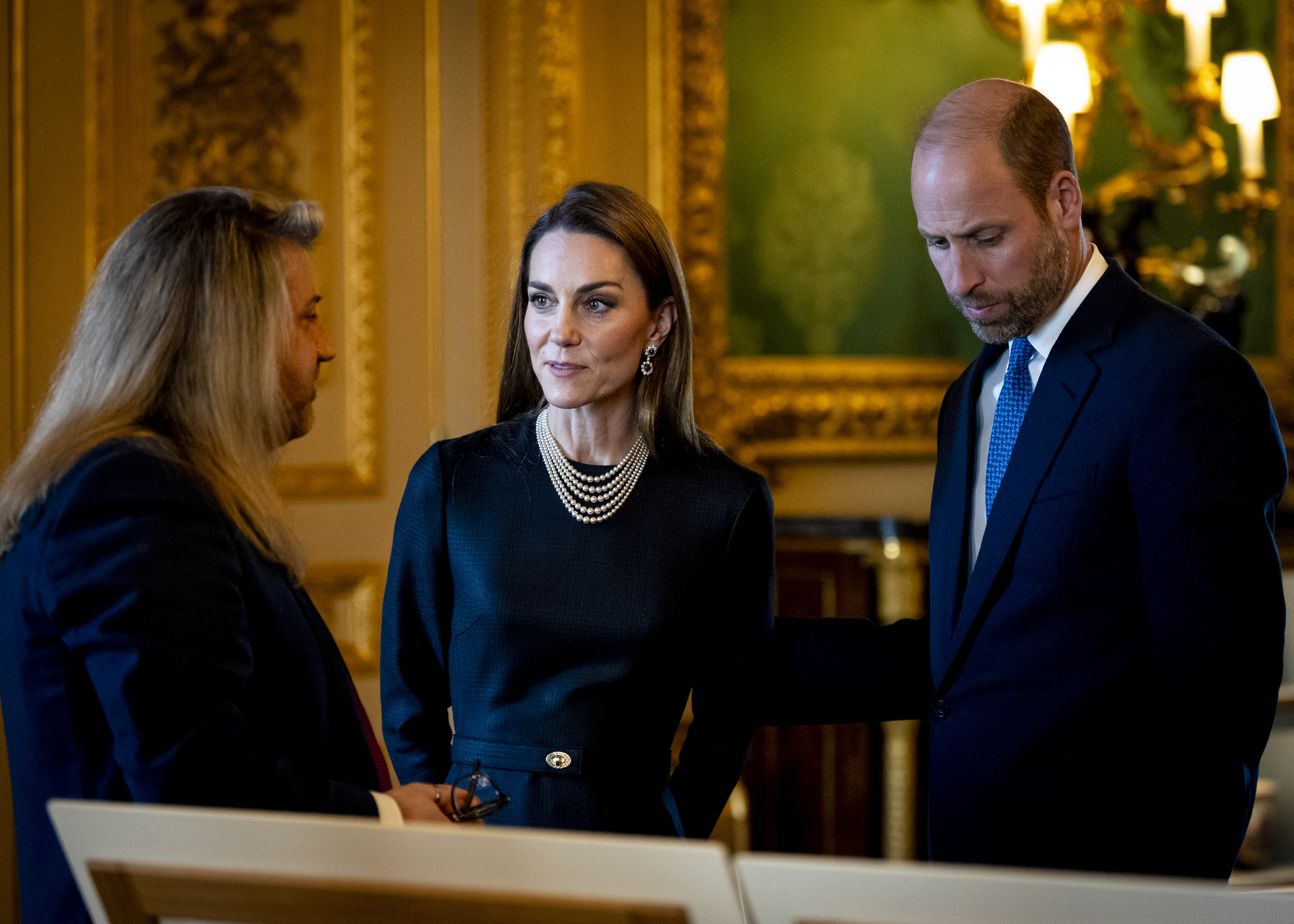 Kate and William looking at a canvas with serious expressions