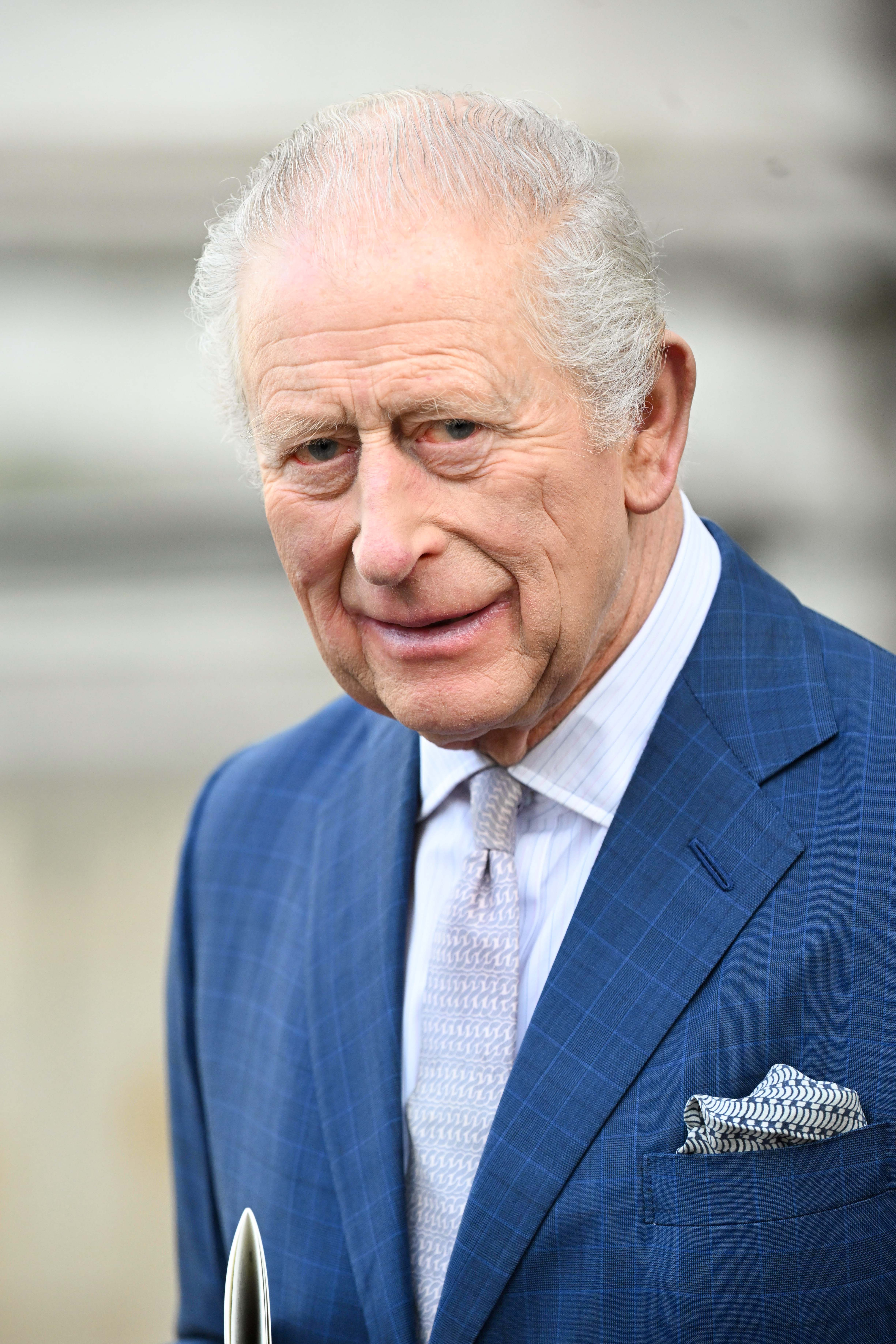 King Charles with a strained smile