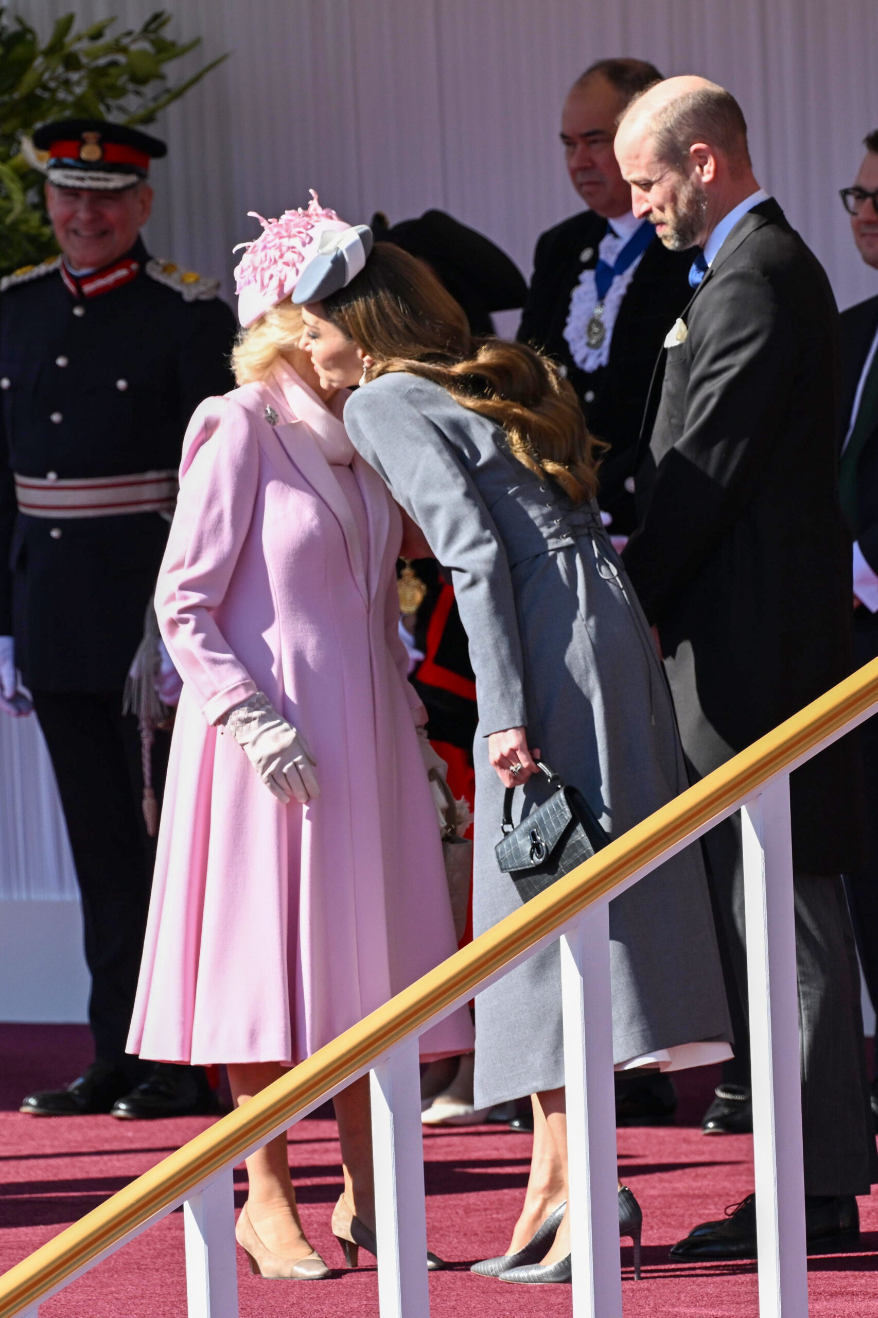 Queen Camilla sharing a kiss with Kate Middleton during state visit