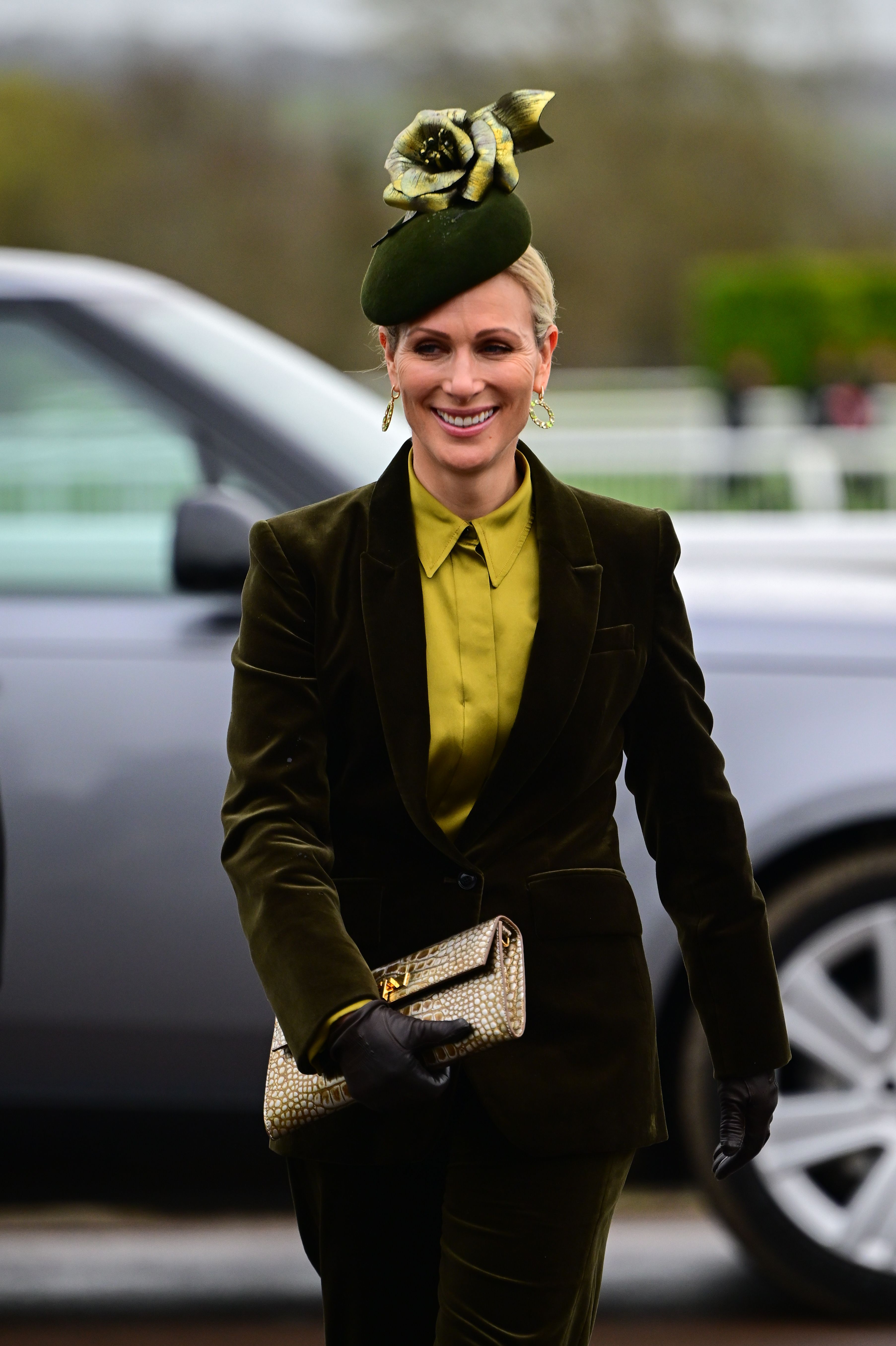 Zara Tindall in a green blouse, velvet suit and a floral hat at Cheltenham