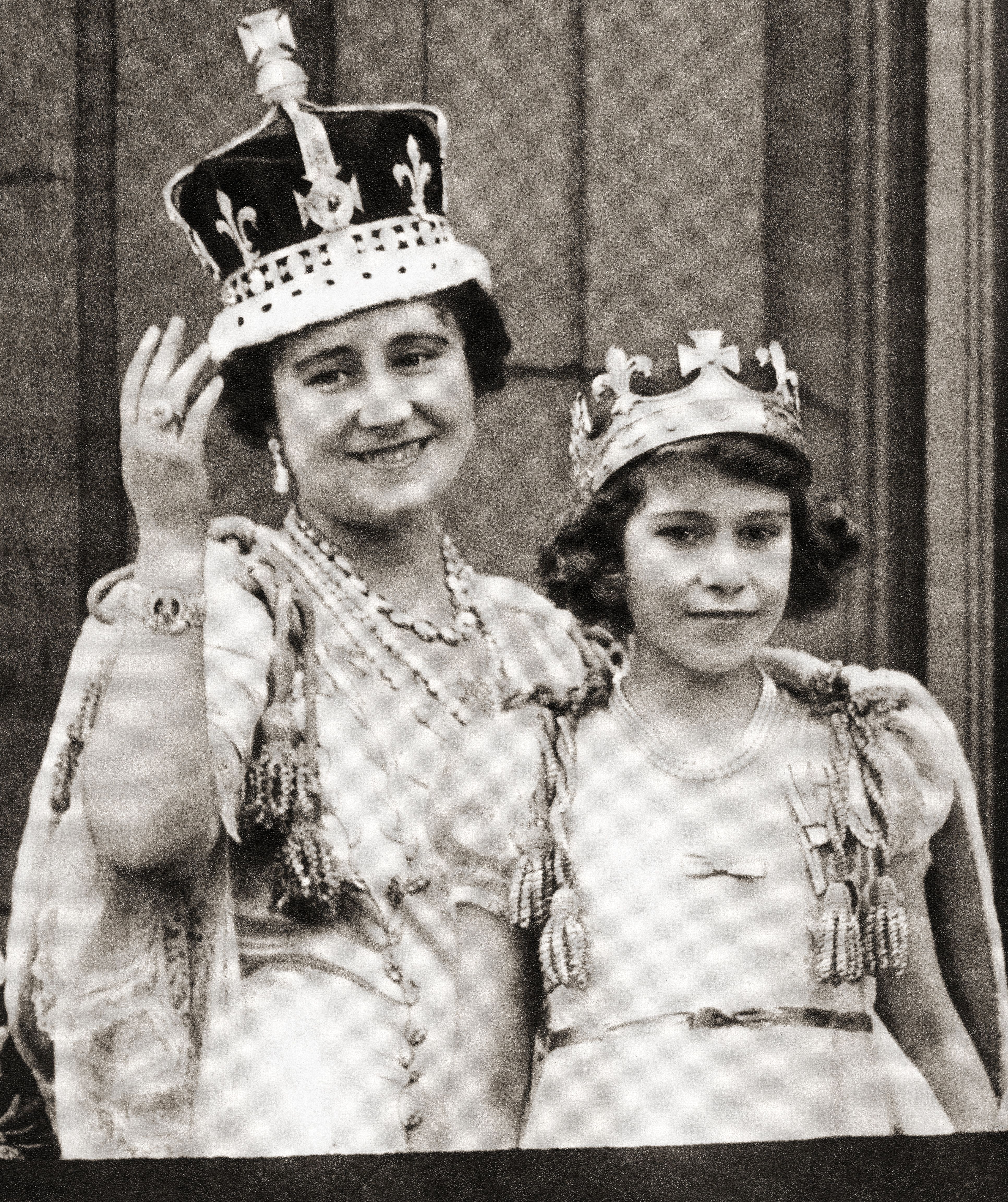 The Queen Mother, Elizabeth Bowes-Lyon wearing a crown and waving beside a young Princess Elizabeth, later Queen Elizabeth