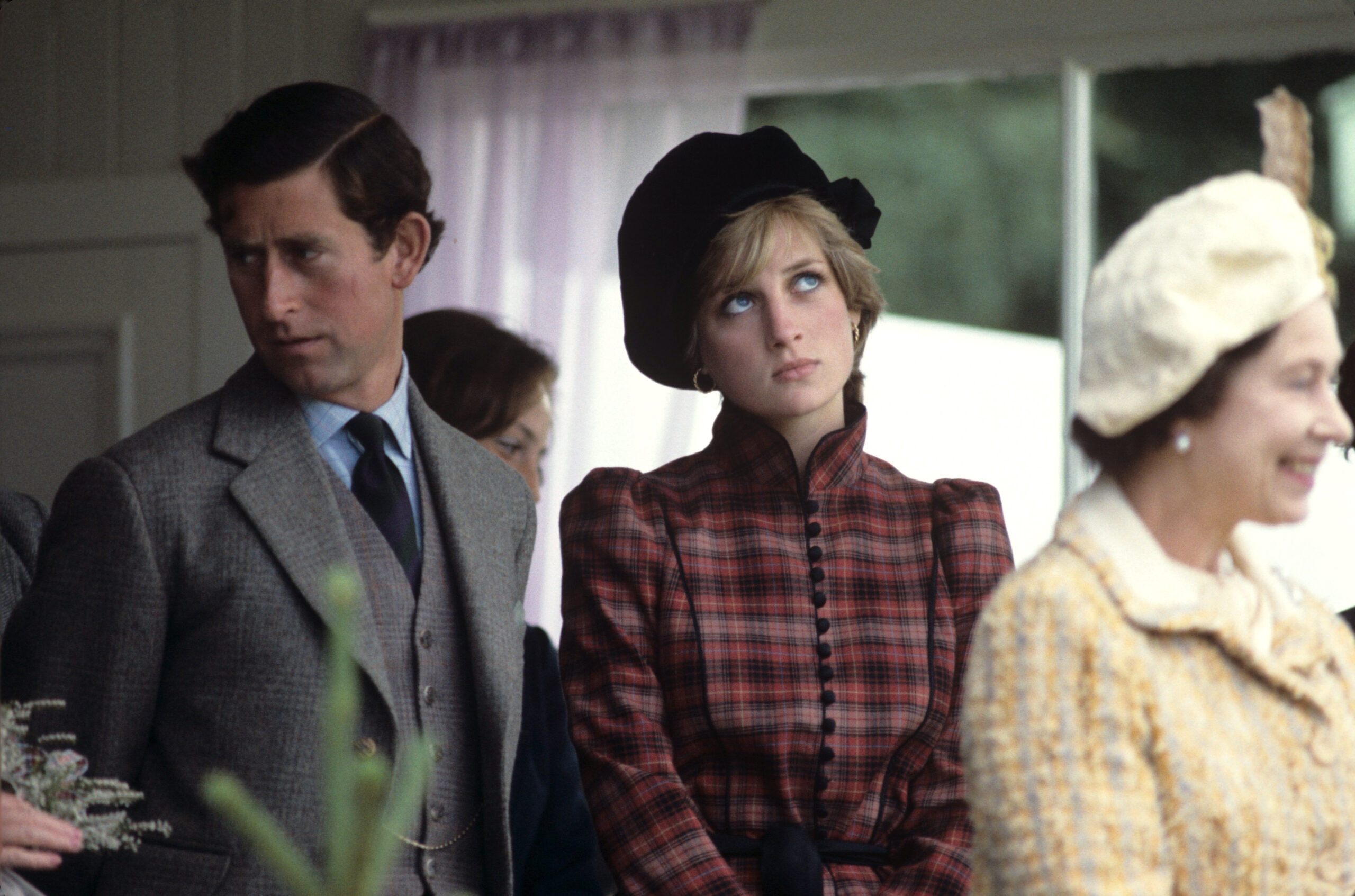 Prince Charles frowning beside Princess Diana, also frowning and looking away