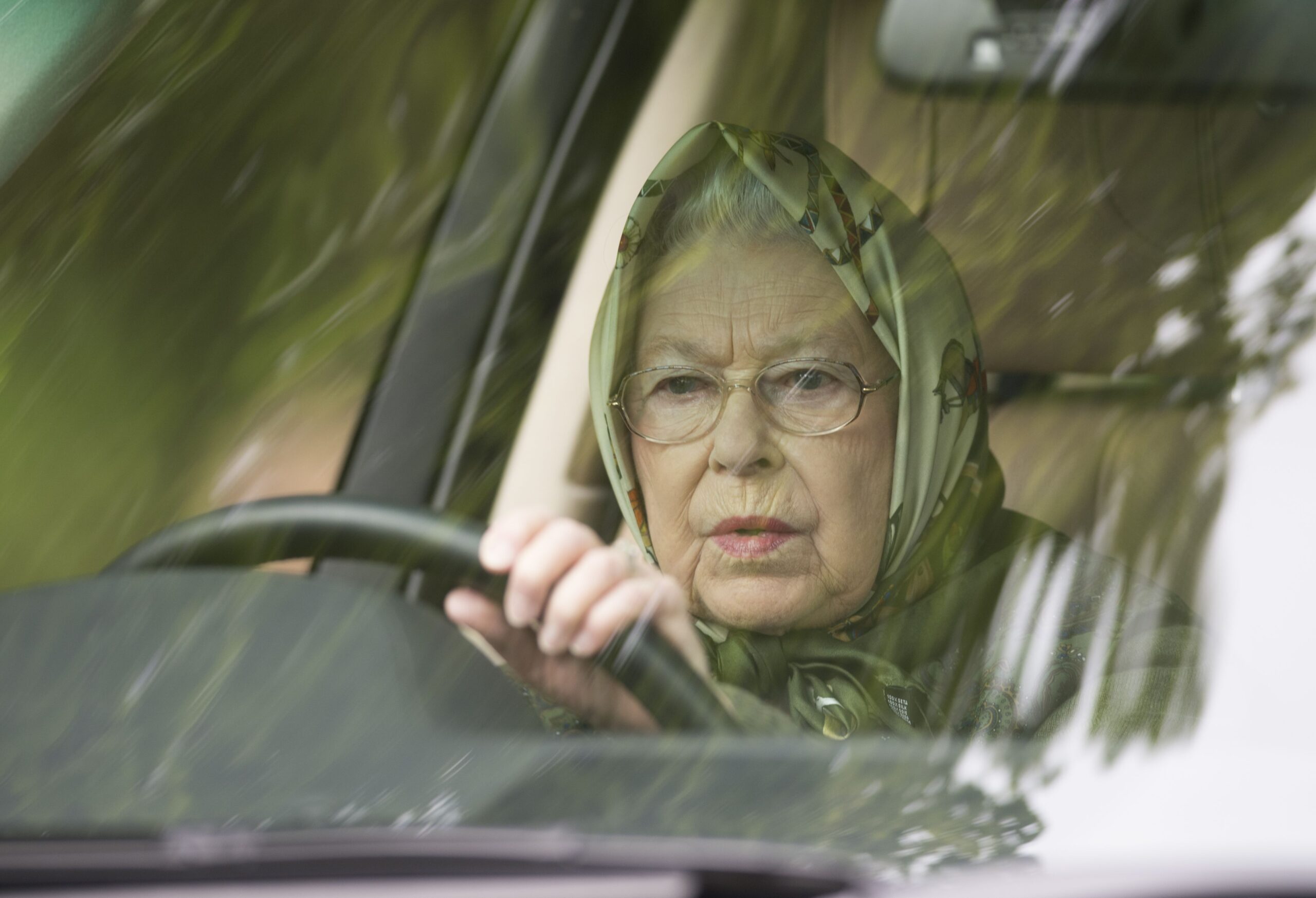 Queen Elizabeth driving with a scarf covering her hair