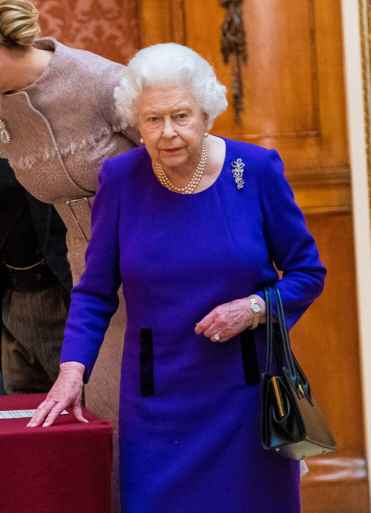 Queen Elizabeth II frowning wearing blue