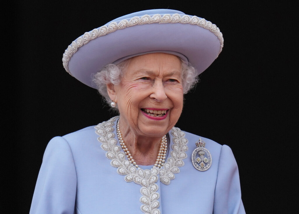 Queen Elizabeth II smiling in blue at platinum jubilee celebrations