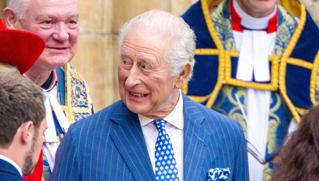 King Charles smiling in blue suit